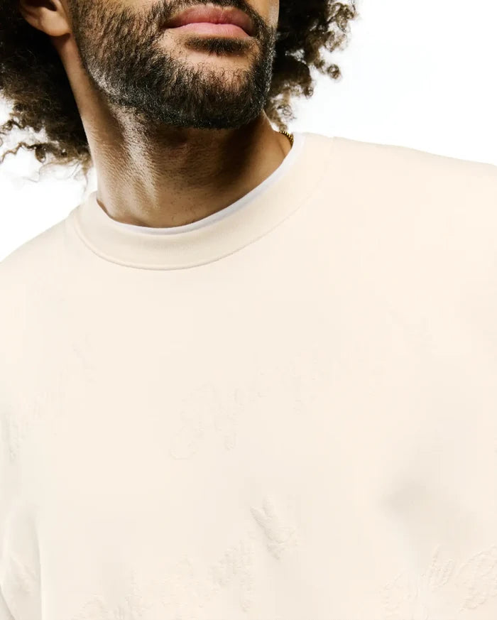 Cream Mens Cedrick All Over Jacquard Crew, a relaxed fit sweatshirt with a subtle tone-on-tone jacquard knit featuring the iconic Psycho Bunny skull logo and brand text throughout.