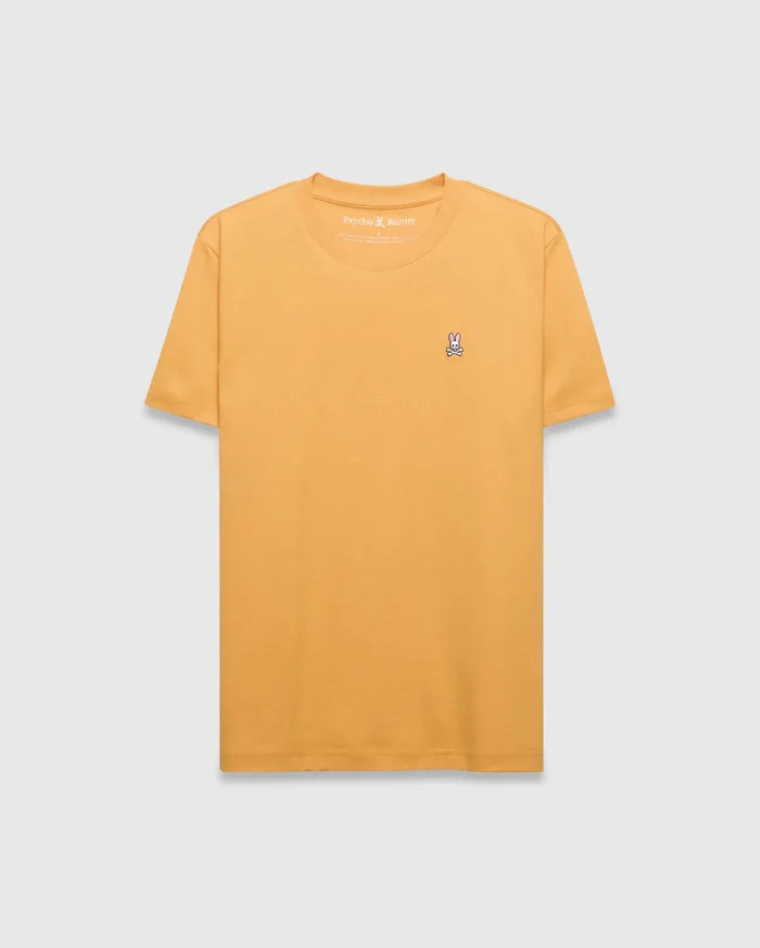 Mens Classic Crew Neck Tee in mustard yellow, featuring a classic fit and smooth jersey fabric. Small embroidered pink, white, and black Psycho Bunny skull logo on the left chest.