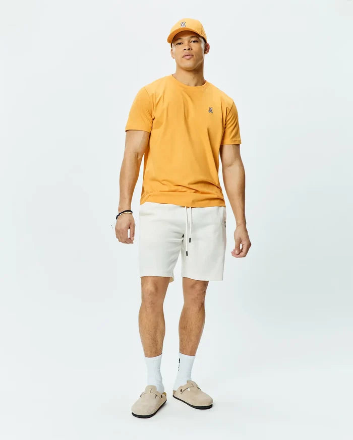 Mustard Yellow Mens Classic Crew Neck Tee in soft jersey knit, featuring a classic fit and a small embroidered black and white Psycho Bunny skull logo on the left chest.