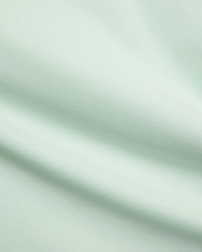 Mens Classic Crew Neck Tee in a premium, soft pale mint green jersey fabric, showcasing a smooth, refined texture with subtle diagonal knit details, characteristic of Psycho Bunny's elevated streetwear.