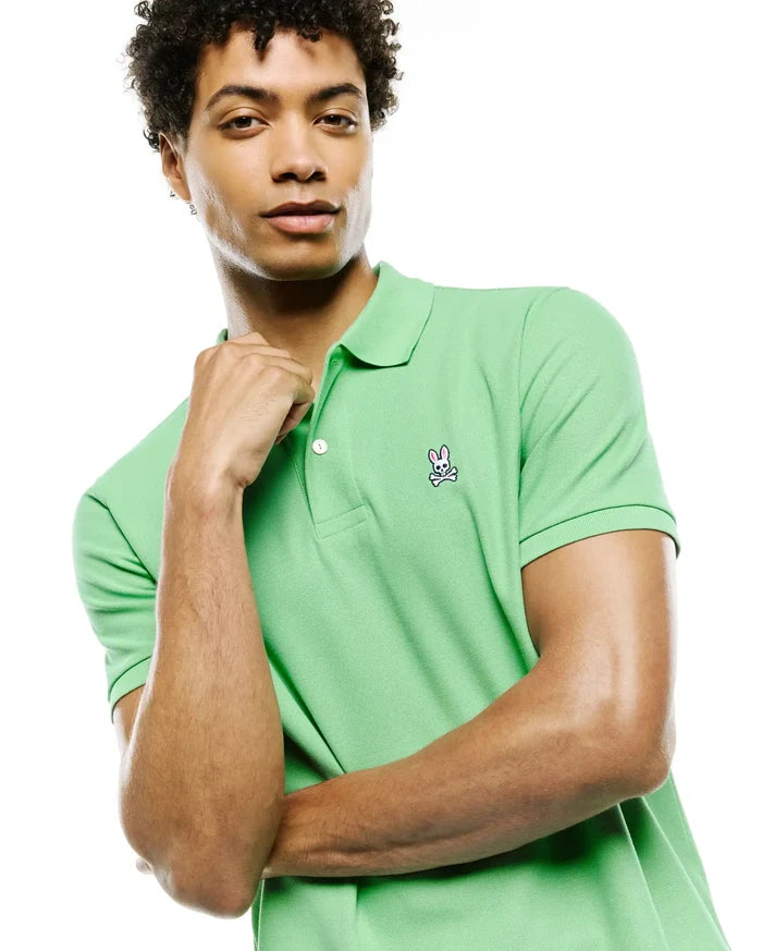 Mens Classic Pique Polo in vibrant lime green, featuring a classic fit, two-button placket with white buttons, and a detailed embroidered Psycho Bunny skull logo on the left chest.