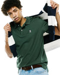Mens Classic Pique Polo in forest green, classic fit, pique knit, with white buttons, a two-button placket, and a small embroidered pink and white Psycho Bunny skull logo on the left chest.