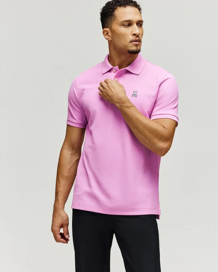 Mens Classic Pique Polo in vibrant pink, featuring a classic fit, textured pique fabric, and a small, embroidered white Psycho Bunny skull logo on the left chest with white buttons.