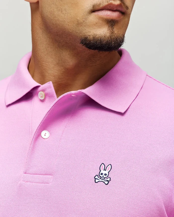 Mens Classic Pique Polo in vibrant pink pique fabric, featuring a classic fit, two white buttons, and a small embroidered Psycho Bunny skull logo with pink ears on the left chest.