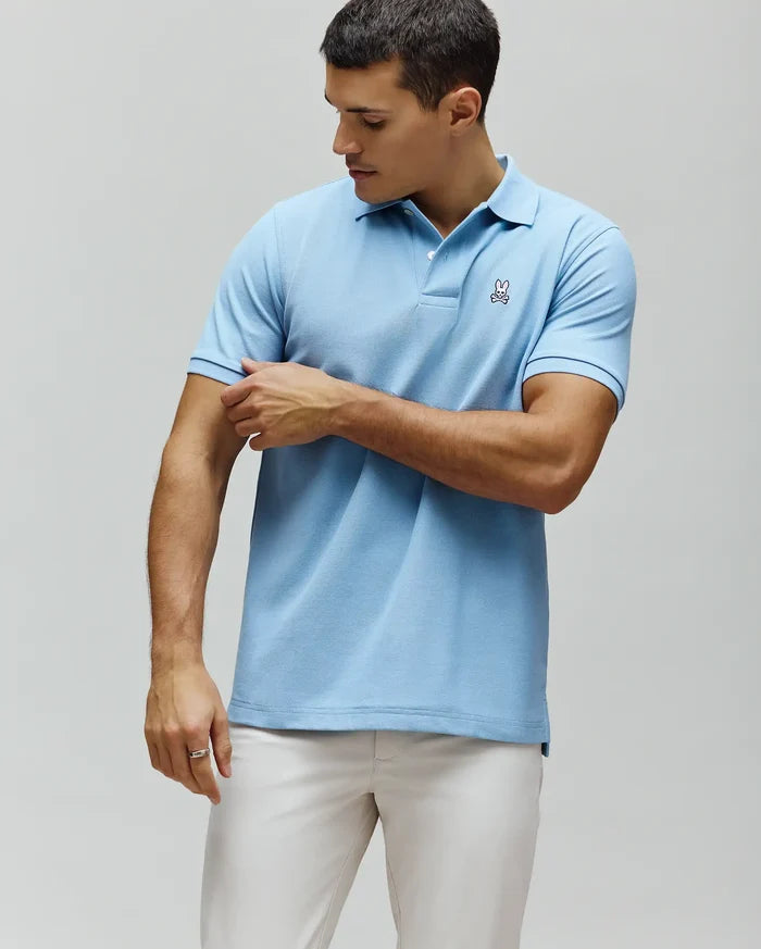 Mens Classic Pique Polo, light blue classic fit pique knit with a two-button placket and a small embroidered Psycho Bunny skull logo on the left chest.
