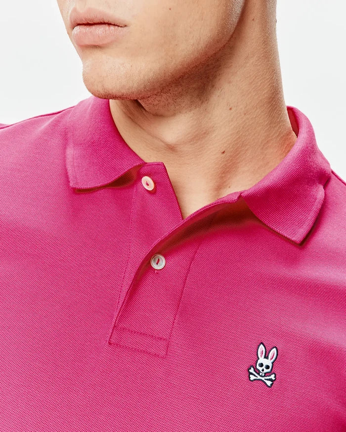 Mens Classic Pique Polo in vibrant fuchsia, featuring a classic fit, pique knit texture, two-button placket, and a small embroidered Psycho Bunny skull logo on the left chest.