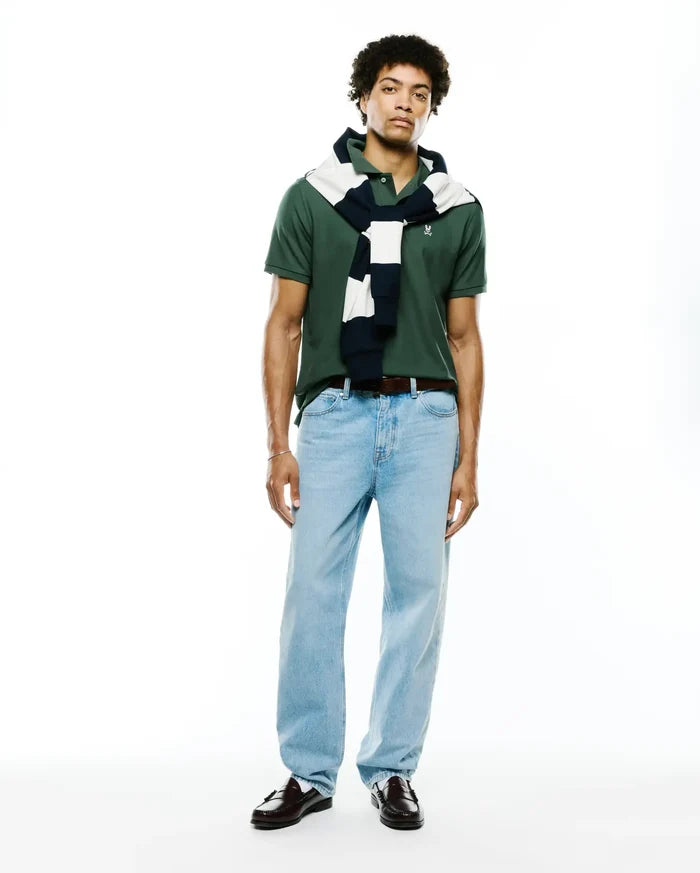 Mens Classic Pique Polo in deep forest green, showcasing a classic fit, textured pique fabric, and a small, crisp white embroidered Psycho Bunny skull logo on the left chest.