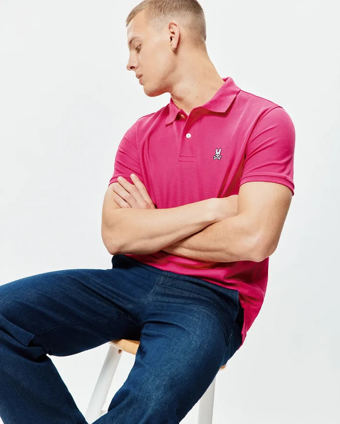 Mens Classic Pique Polo in hot pink, featuring a classic fit, pique knit texture, two white buttons on the placket, and a small white and black embroidered Psycho Bunny skull logo on the left chest.