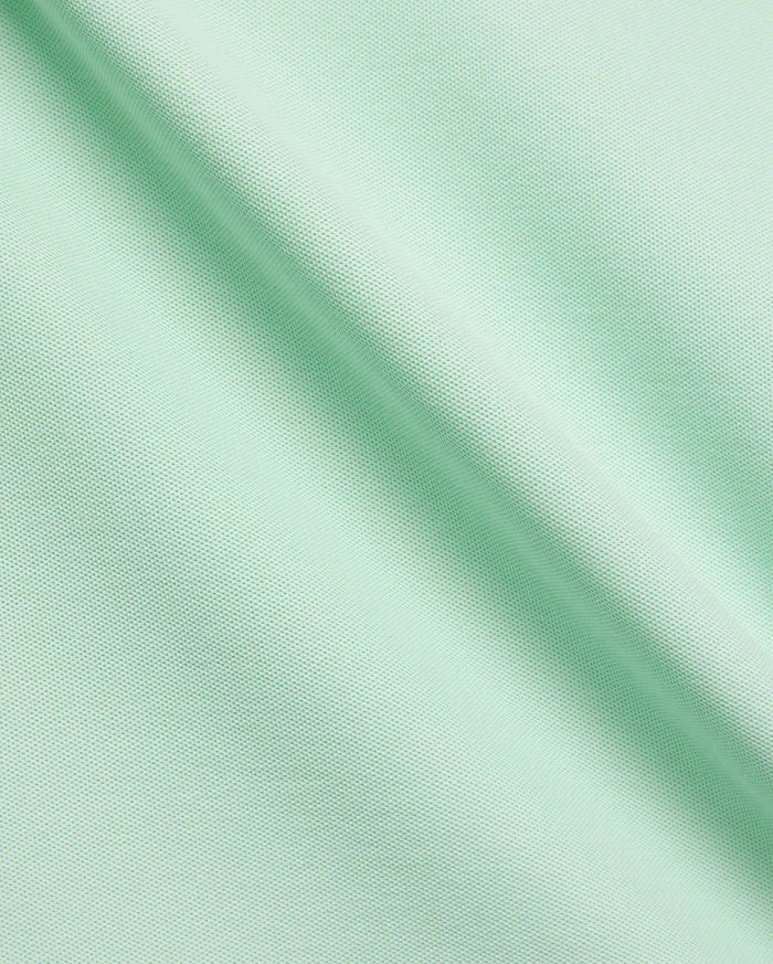 Vibrant Mint Green MENS CLASSIC PIQUE POLO fabric, showcasing its distinctive textured pique knit, soft drape, and premium quality, ideal for refined streetwear.