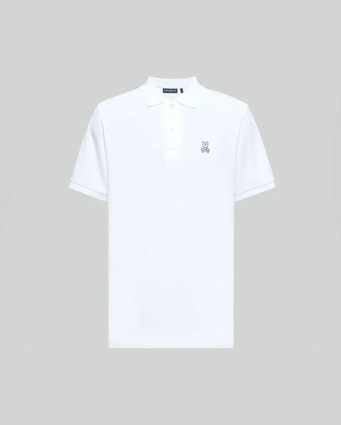 Mens Classic Pique Polo Shirt in crisp white, classic fit, pique knit, with a two-button placket, ribbed collar and cuffs, and a small embroidered pink/purple Psycho Bunny skull logo on the left chest.