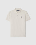 A timeless men's classic pique polo in luxurious Pima cotton, this plain, short-sleeved shirt in off-white features a collar, two buttons, and a small embroidered bunny logo on the left chest. The product is the MENS CLASSIC PIQUE POLO SHIRT - B6K001B200 by Psycho Bunny.