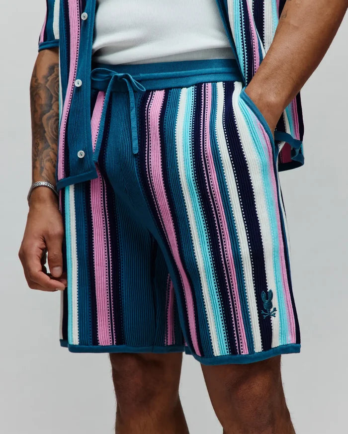 Mens Cliff Knit Short with vibrant teal, pink, light blue, white, and navy vertical stripes. Features a ribbed knit texture, drawstring waist, and small embroidered Psycho Bunny skull logo on the lower right leg.