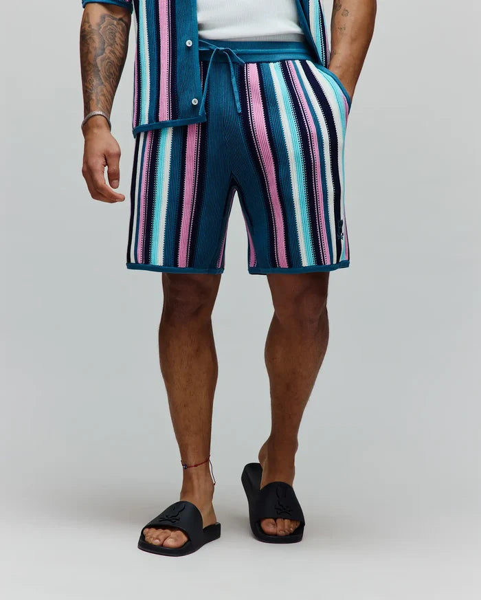 Mens Cliff Knit Short, a relaxed fit knit short with bold teal, pink, white, light blue, and navy vertical stripes, featuring a small embroidered Psycho Bunny skull logo on the lower left leg and a drawstring waist.