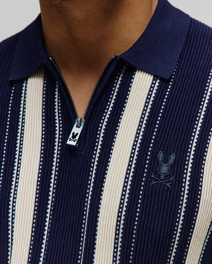 Mens Cliff Knit Zip Polo in navy and cream vertical stripes with a ribbed knit texture, featuring a small embroidered Psycho Bunny skull logo on the left chest and a branded zipper pull.