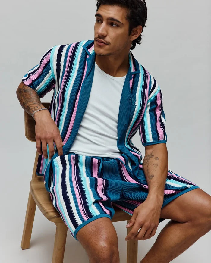 MENS CLIFF SHIRT, a relaxed fit, short-sleeve knit shirt in vibrant teal, pink, white, and navy vertical stripes, featuring a small embroidered Psycho Bunny skull logo on the chest.