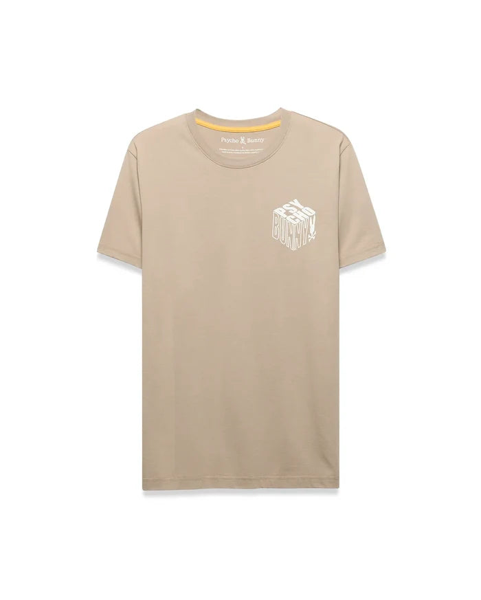 Mens Conan Back Graphic Tee, a classic fit tan jersey t-shirt featuring a large white 3D-effect Psycho Bunny text and skull logo graphic on the left chest, with yellow inner neck tape.