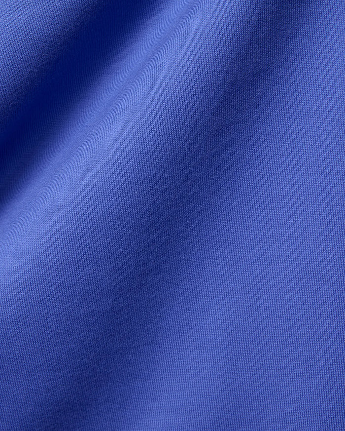 Mens Craig Wordmark Tee crafted from a premium, vibrant blue jersey knit fabric, showcasing a smooth texture with subtle vertical ribbing and elegant, soft folds.
