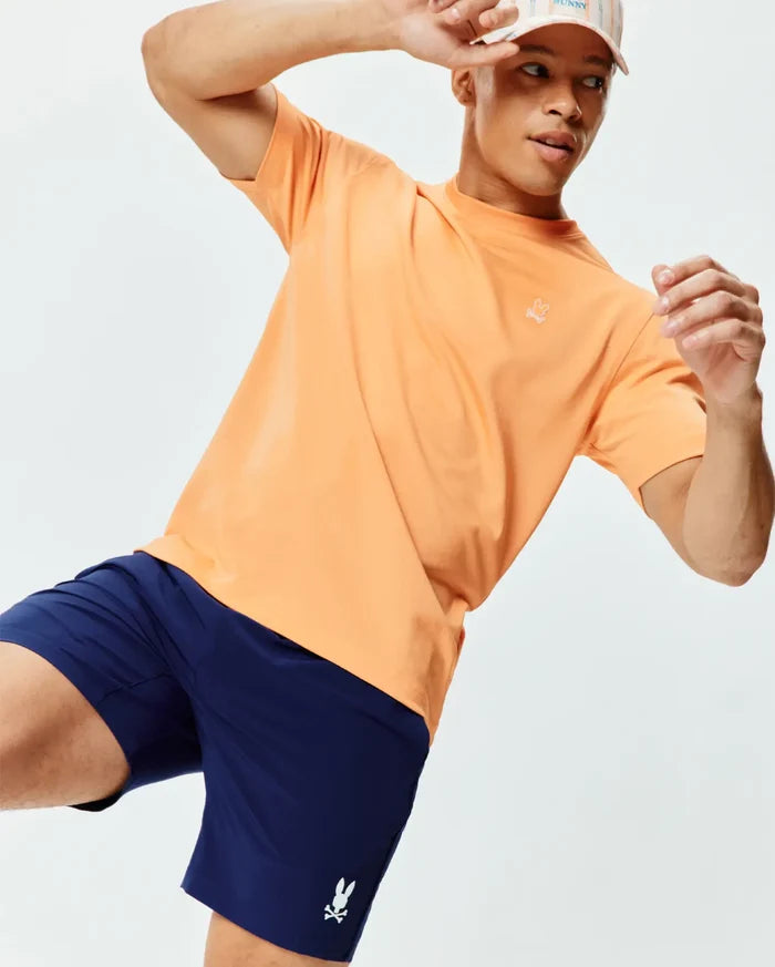 Mens Dash Bunny Sport Tee, a relaxed peach jersey t-shirt with a small white embroidered bunny skull logo on the left chest, paired with navy athletic shorts featuring a white bunny skull logo.
