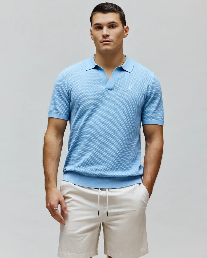 Mens Devon Knit Polo, sky blue textured knit with an open collar, classic fit, and a small embroidered white Psycho Bunny skull logo on the left chest, featuring ribbed cuffs and hem.