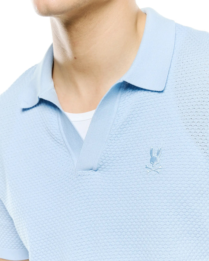 Mens Devon Bubble Stitch Knit Polo in light blue, featuring a unique bubble stitch texture, open placket, and a small, tonal embroidered Psycho Bunny skull logo on the left chest.