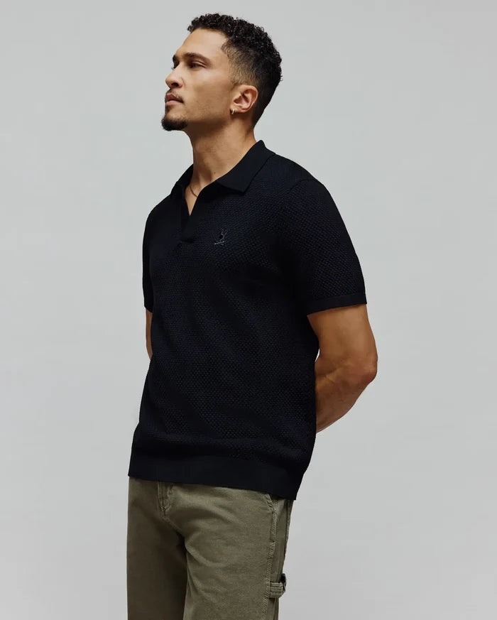 Black Mens Devon Knit Polo, a classic fit, textured knit polo shirt featuring a small, embroidered Psycho Bunny skull logo on the left chest.