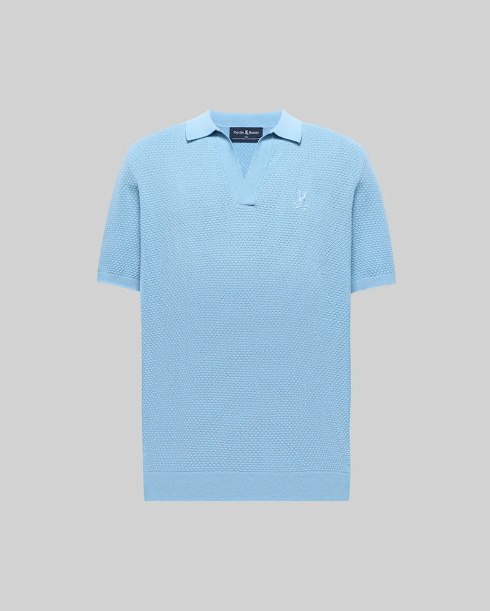 Light blue Mens Devon Knit Polo with a textured knit fabric, open V-neck collar, ribbed cuffs and hem, and a small white embroidered Psycho Bunny skull logo on the left chest.