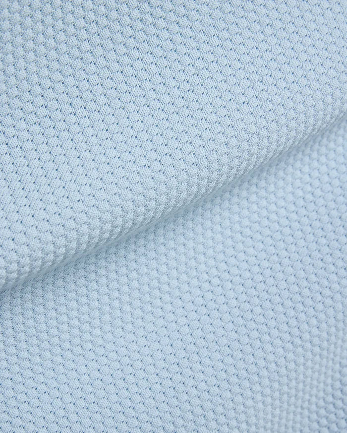 Light blue Mens Devon Bubble Stitch Knit Polo fabric, a premium menswear piece showcasing its unique, refined bubble stitch knit texture, perfect for sophisticated streetwear.