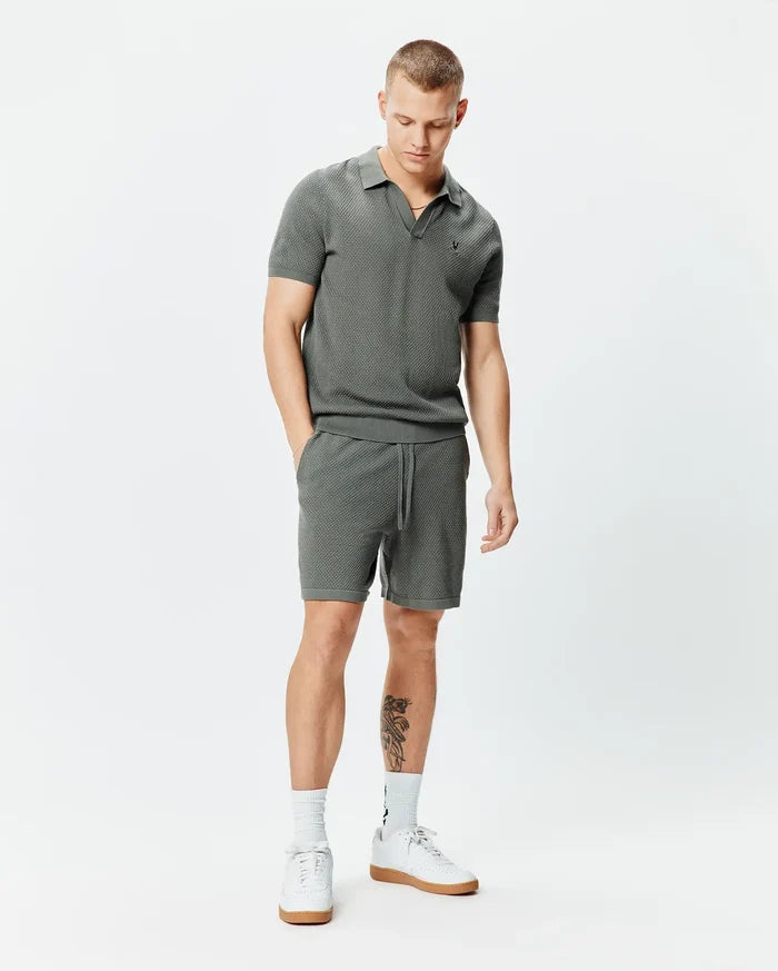 Charcoal grey pique knit polo shirt with small embroidered Psycho Bunny skull logo on left chest and matching Mens Devon Knit Short 7 with drawstring waist, both in a classic fit.