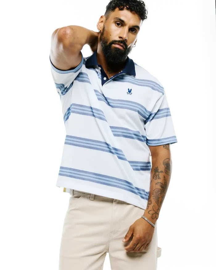 Mens Drew Striped Pique Polo, a classic fit white pique polo with horizontal blue stripes, a navy collar, and a small embroidered Psycho Bunny skull logo on the left chest.