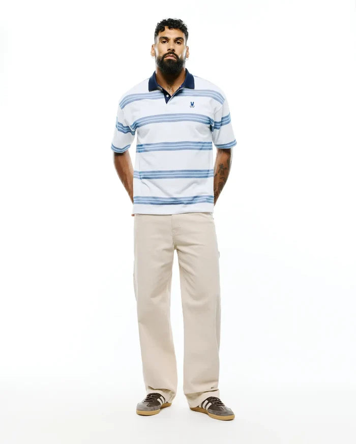 Mens Drew Striped Pique Polo, a classic fit white pique polo with navy collar, light blue horizontal stripes, and a small embroidered Psycho Bunny skull logo on the left chest.