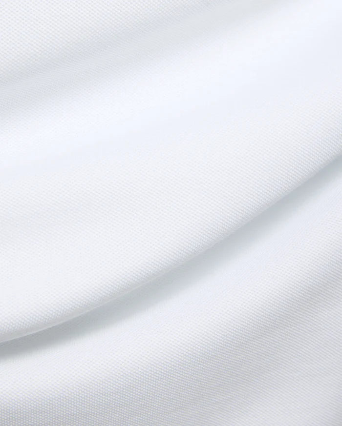 Mens Duncan Pique Polo in crisp white, a premium classic fit polo crafted from finely textured pique knit fabric, embodying Psycho Bunny's refined streetwear aesthetic.