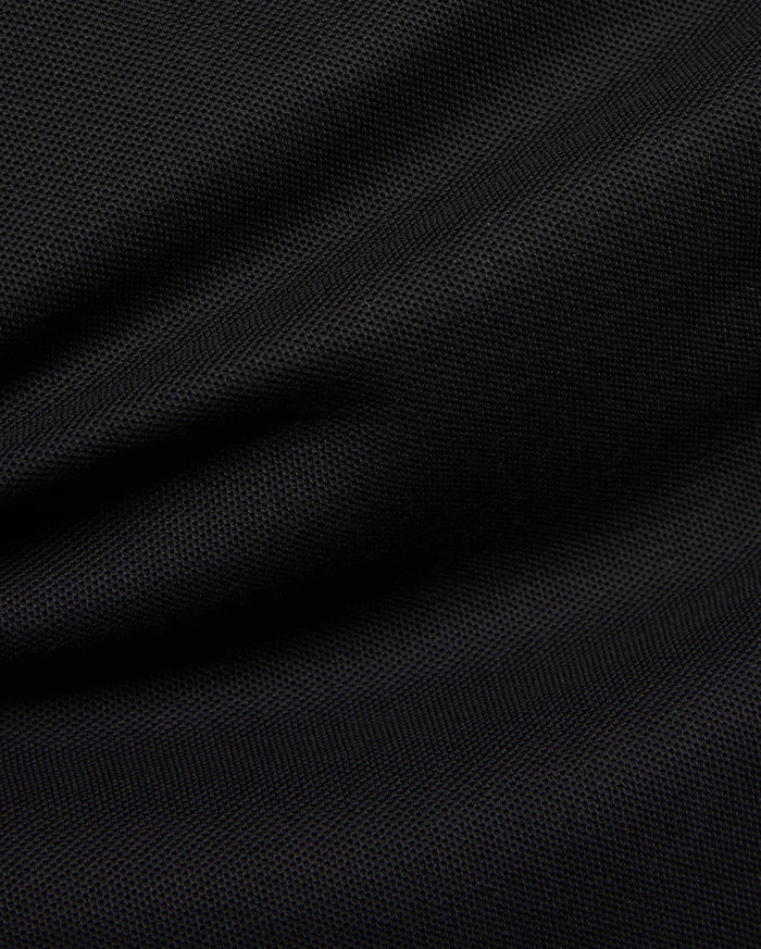 Premium black Mens Duncan Pique Polo, showcasing its breathable, classic pique fabric with a distinct textured weave and subtle folds, perfect for refined streetwear.