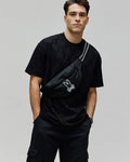 Mens Dustin Oversized Tee, a black oversized t-shirt with an all-over embossed checkerboard pattern featuring the Psycho Bunny skull logo, crafted from textured jersey fabric.