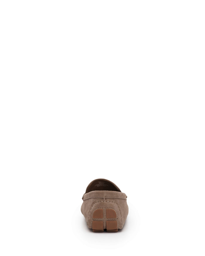 The Vince Camuto Men’s Eadric Casual Driving Shoe is displayed from the back in taupe suede, highlighting visible stitching and a brown rubber sole with grip details. These stylish shoes combine exceptional comfort with modern design. The image features a plain white background.