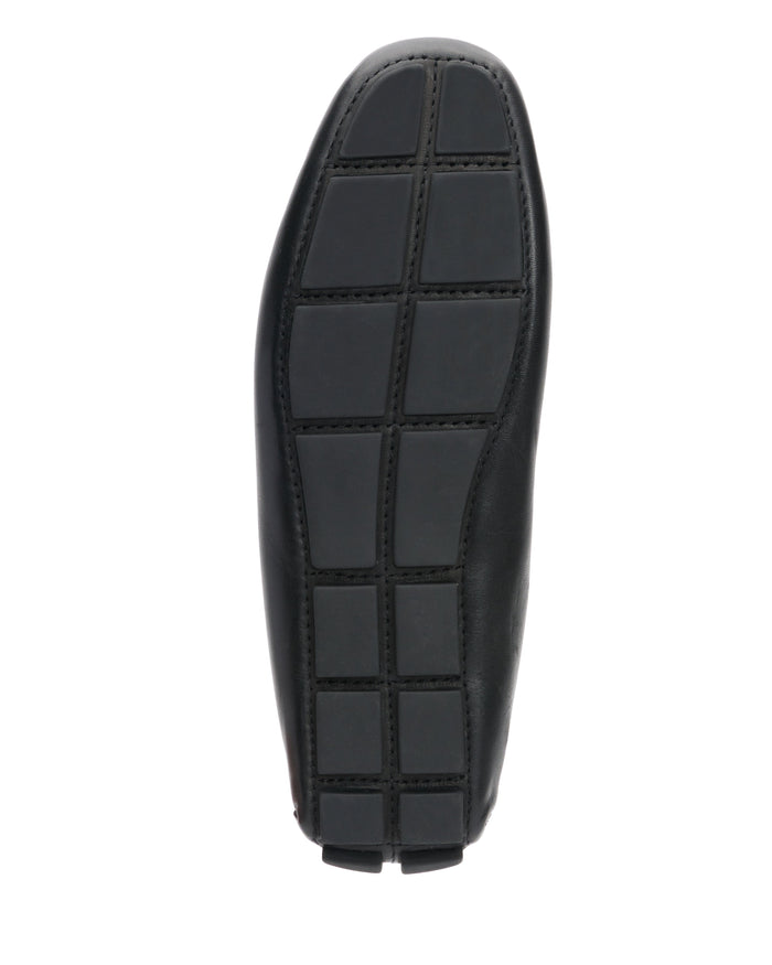 The Vince Camuto Men’s Eadric Casual Driving Shoe features a black sole with a geometric, grid-like tread pattern, captured from the bottom against a white background—an ideal pick for anyone seeking comfortable footwear that maintains a stylish edge.