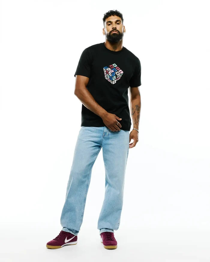 Mens Eddy Graphic Tee, a black classic fit jersey t-shirt featuring a large, colorful Rubik's Cube-style graphic on the chest spelling PSYCHO BUNNY in bright block letters.