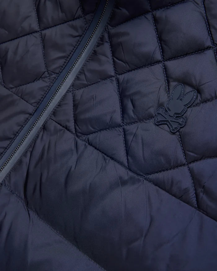 Mens Emerik Puffer Jacket, a navy quilted puffer jacket crafted from smooth nylon, featuring a dark zipper and a small, rubberized Psycho Bunny skull logo on the chest.