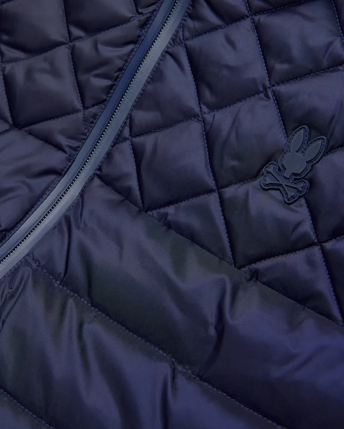 Mens Emerik Puffer Vest in navy, featuring a diamond quilted pattern, full-zip closure with dark trim, and a small, matching navy rubberized Psycho Bunny skull logo on the chest.