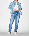 Light blue classic fit denim jacket over a white jersey t-shirt, paired with MENS EMERSON DENIM PANT, a slim fit medium wash denim with subtle fading. Black Psycho Bunny logo waistband with repeating bunny skulls.