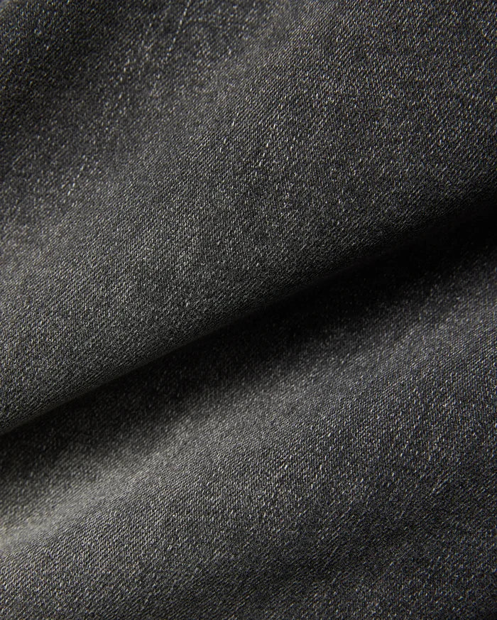 Mens Emerson Denim Pant featuring a dark charcoal grey denim fabric with a visible twill weave and subtle light flecks, creating a textured, washed appearance.