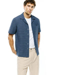 Mens Erik Raised Check Shirt: Relaxed fit navy and light blue textured short-sleeve shirt with a camp collar, featuring a subtle raised check pattern and a small embroidered Psycho Bunny skull logo on the left chest.