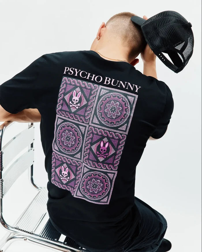 Mens Frank Back Graphic Tee, a black classic fit jersey t-shirt featuring a large back graphic with intricate pink and purple mandala patterns and multiple small Psycho Bunny skull logos, topped with pink PSYCHO BUNNY text.