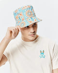 Cream jersey t-shirt with a blue and orange Psycho Bunny skull logo on the left chest, paired with a Mens Frank Reversible Bucket Hat featuring a white, blue, and orange intricate pattern with small bunny skulls.