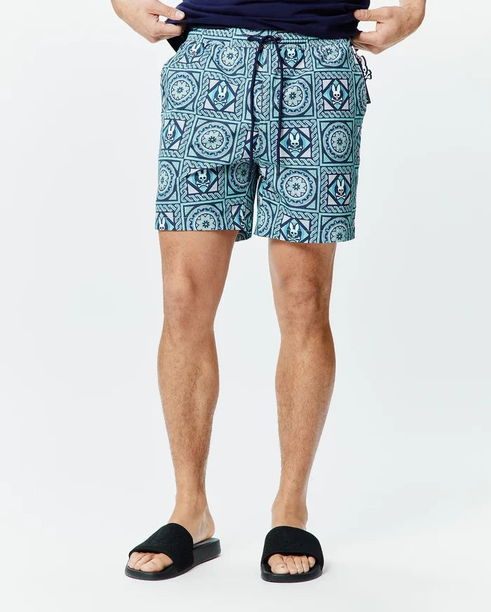 Mens Frank Swim Trunk 6, aqua and navy blue with an all-over geometric pattern featuring the Psycho Bunny skull logo, classic fit, quick-dry fabric, and navy drawstring.