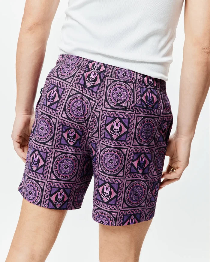 Mens Frank Swim Trunk 6, a purple and black mosaic pattern swim trunk with repeated pink Psycho Bunny skull logos, featuring a relaxed fit and smooth fabric.