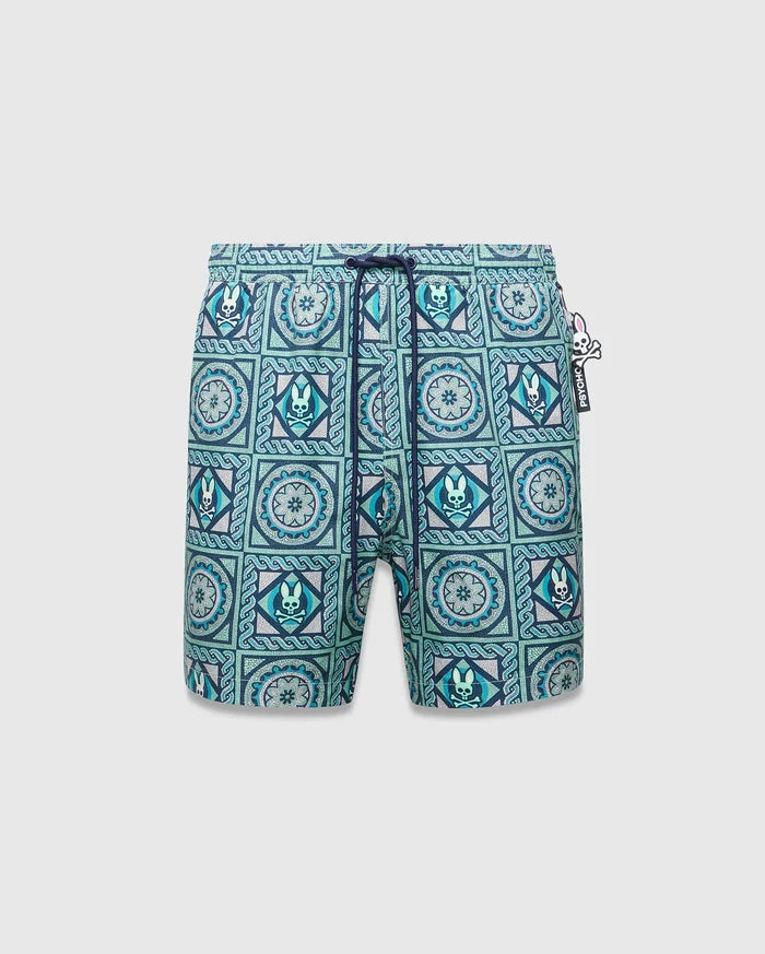 Mens Frank Swim Trunk 6, classic fit, vibrant teal, blue, and white mosaic tile pattern with repeated Psycho Bunny skull logos, floral motifs, dark blue drawstring, and a Psycho Bunny hip tag.