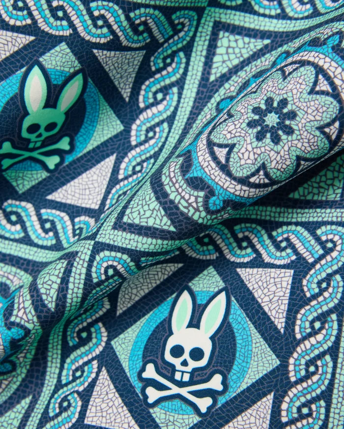 Mens Frank Swim Trunk 6, a navy blue fabric with a detailed mosaic print in teal, light green, and white, featuring the repeated iconic Psycho Bunny skull logo.