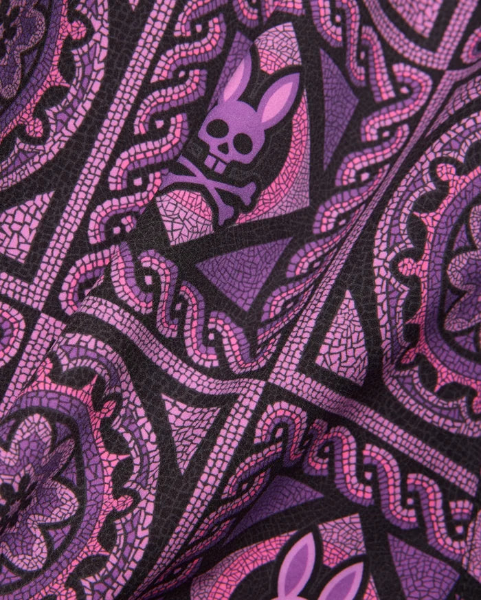 Mens Frank Swim Trunk 6 featuring a vibrant black, purple, and pink mosaic-style print with repeating Psycho Bunny skull and crossbones logos, on a smooth fabric.
