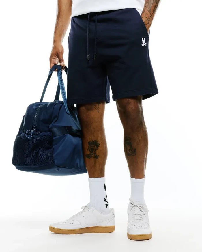 Mens Gabe French Terry Sweatshort in navy blue, featuring a relaxed fit, drawstring waist with silver tips, and a small embroidered white Psycho Bunny skull logo on the left thigh.