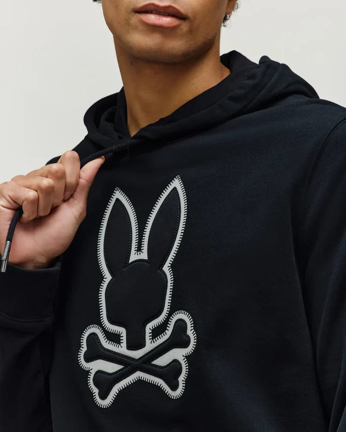 Mens Gage Patch Hoodie, black classic fit hoodie in soft jersey knit, featuring a large central white Psycho Bunny skull logo patch with detailed stitching and branded drawstring aglets.